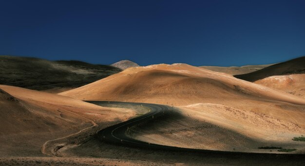 Photo scenic view of desert against clear blue sky