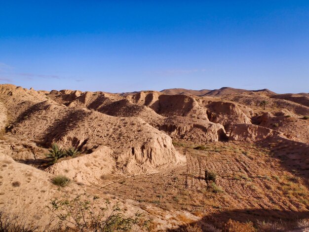 Scenic view of desert against clear blue sky