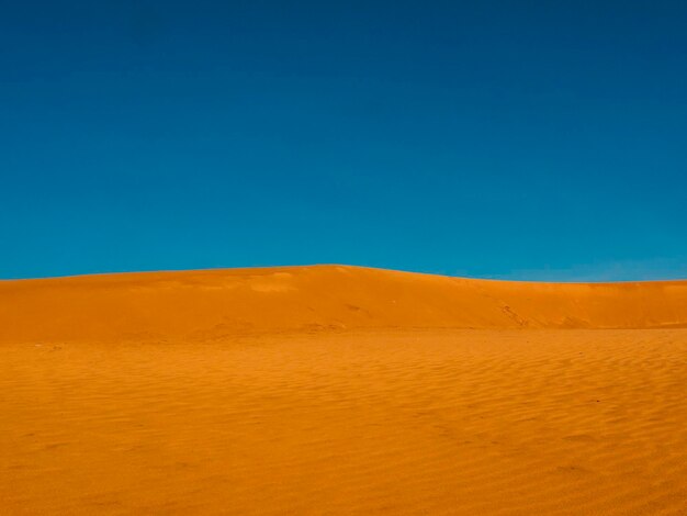 Scenic view of desert against clear blue sky