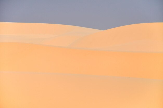 Photo scenic view of desert against orange sky