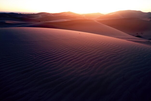 Photo scenic view of desert against sky during sunset