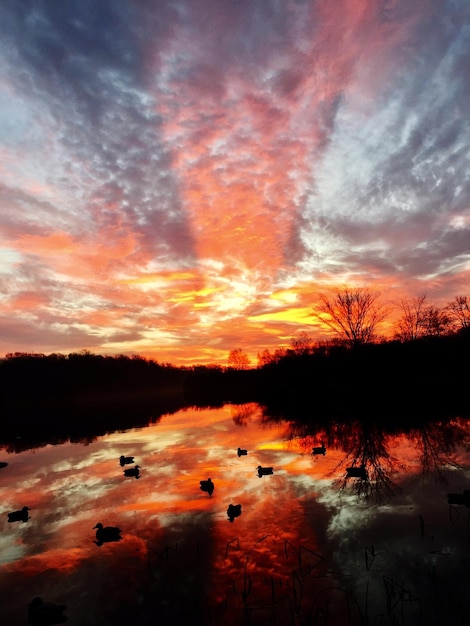 Scenic view of dramatic sky over lake during sunset