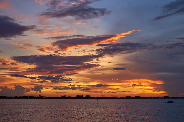 Photo scenic view of dramatic sky over sea during sunset