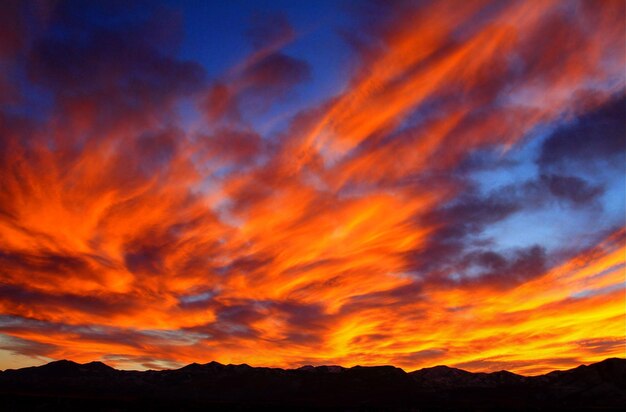 Scenic view of dramatic sky over silhouette landscape