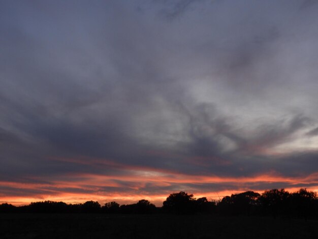 Scenic view of dramatic sky over silhouette landscape