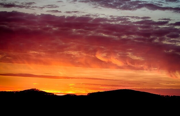 Scenic view of dramatic sky over silhouette landscape