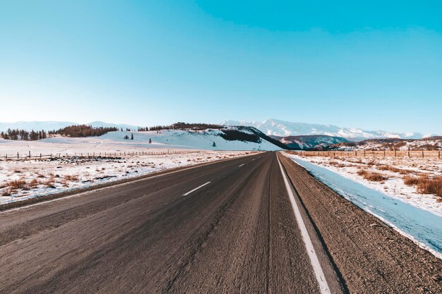 Scenic view of empty road snow covered landscape in winter season