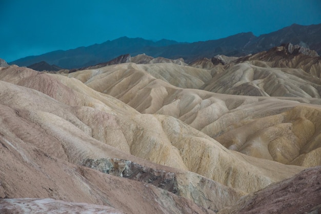 scenic view of eroded landscape against cloudy sky at death valley national park