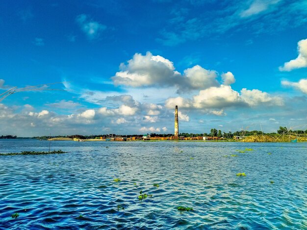 Scenic view of factory against blue sky