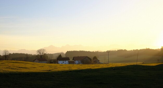 Photo scenic view of farm against sky during sunset