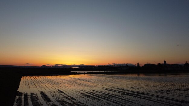 Photo scenic view of field against clear sky during sunset