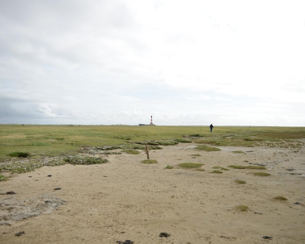 Photo scenic view of field against cloudy sky