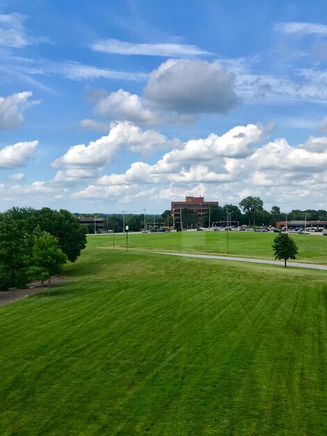 Photo scenic view of field against impressive clouds in the blue skies