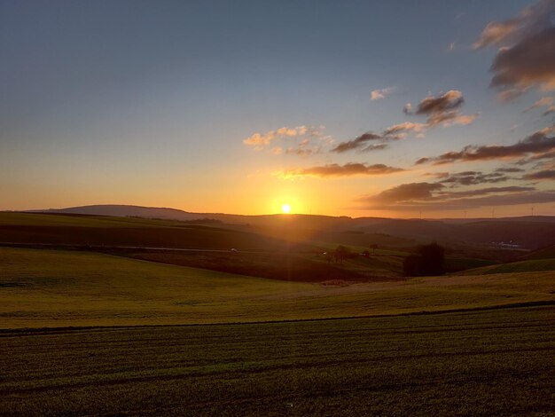 Scenic view of field against sky during sunset