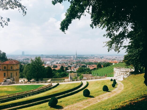 Photo scenic view of field by buildings against sky