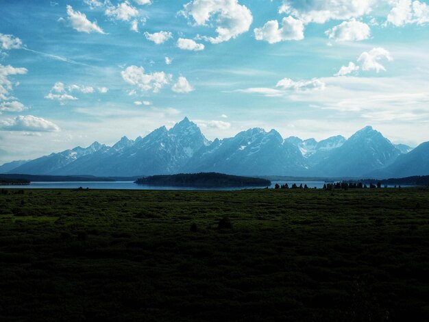 Scenic view of field and mountains against sky