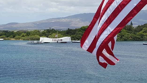 Photo scenic view of flag by lake against sky