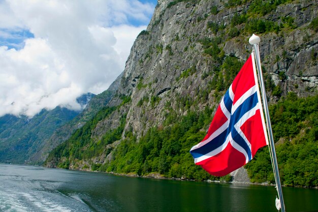 Scenic view of flag by mountains against sky