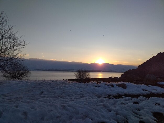 Scenic view of frozen lake against sky during sunset