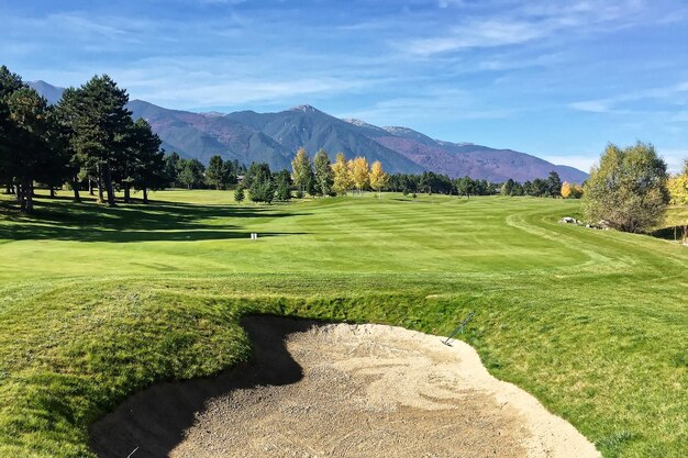 Scenic view of golf course against sky