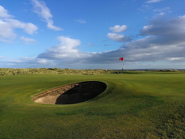 Scenic view of golf course against sky