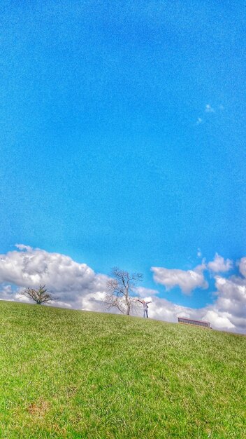 Scenic view of grassy field against cloudy sky