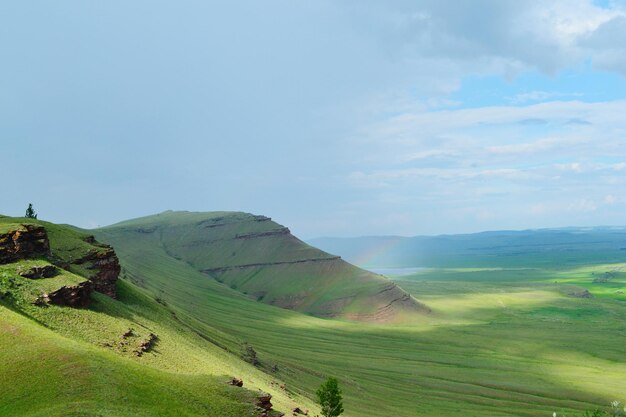 Scenic view of green mountains against sky