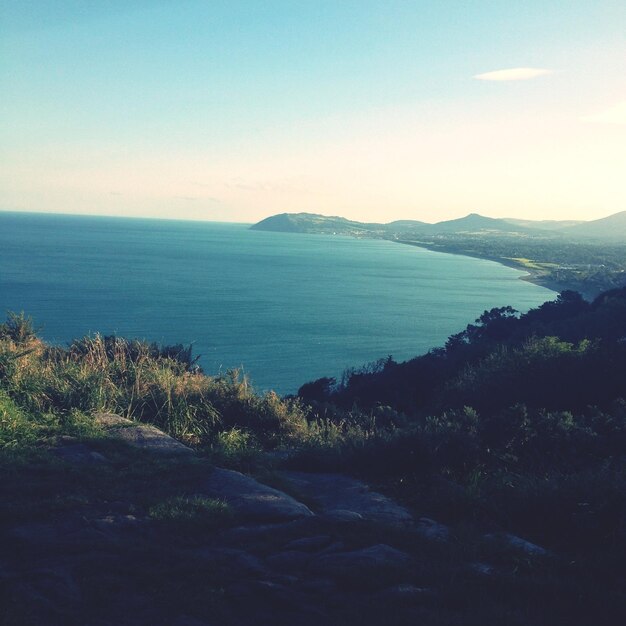 Photo scenic view of hill and sea against sky