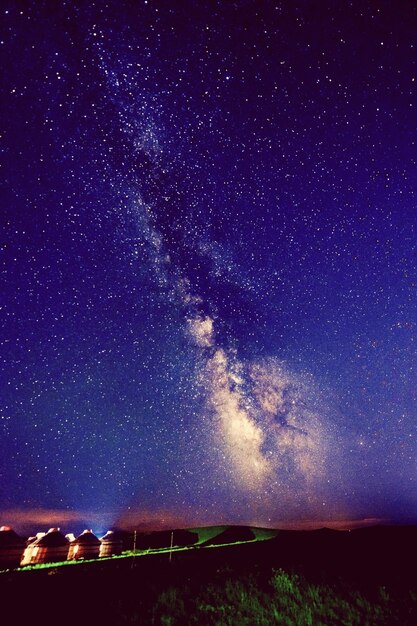 Foto vista panoramica di un campo illuminato contro il cielo notturno