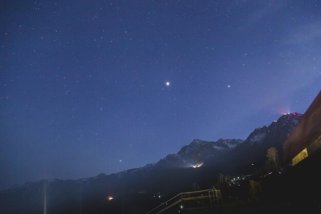 Scenic view of illuminated mountains against sky at night