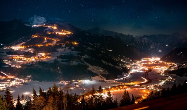 Photo scenic view of illuminated villages and mountains at night