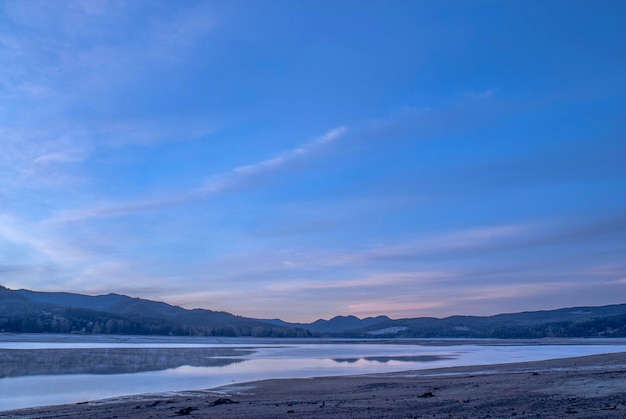 Scenic view of lake against blue sky during winter