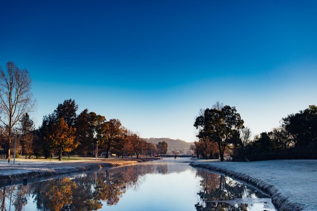 Scenic view of lake against blue sky during winter