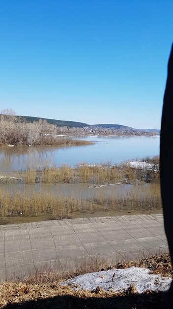 Scenic view of lake against clear blue sky during winter