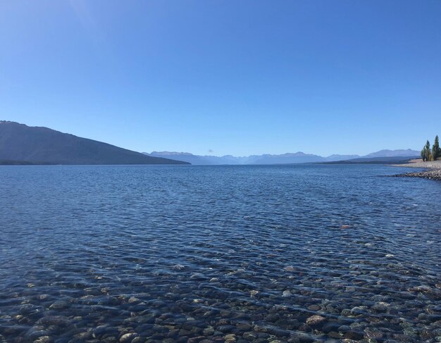 Scenic view of lake against clear blue sky