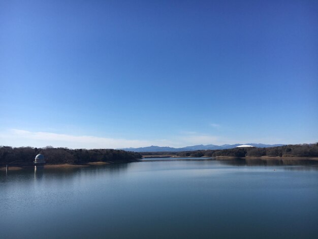 Scenic view of lake against clear blue sky