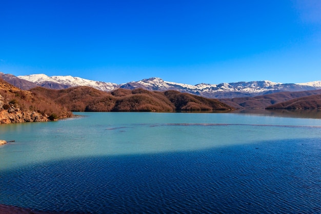 Scenic view of lake against clear blue sky