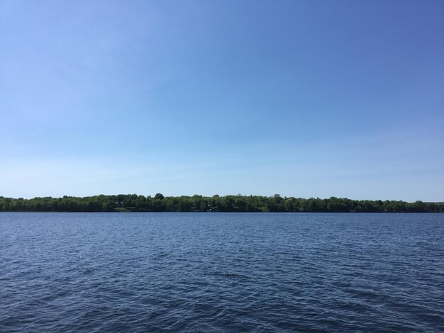 Scenic view of lake against clear blue sky