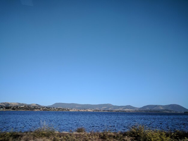 Scenic view of lake against clear blue sky