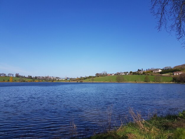 Scenic view of lake against clear blue sky