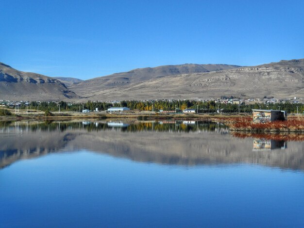 Scenic view of lake against clear blue sky