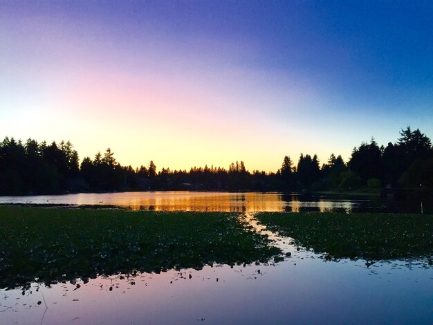 Scenic view of lake against clear sky during sunset