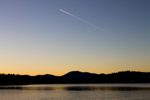 Scenic view of lake against clear sky during sunset