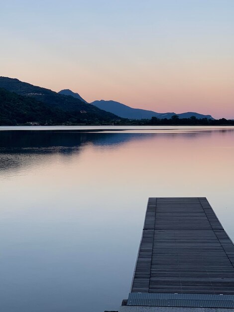 Scenic view of lake against clear sky during sunset