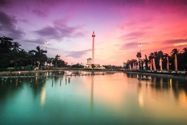 Scenic view of lake against cloudy sky during sunset