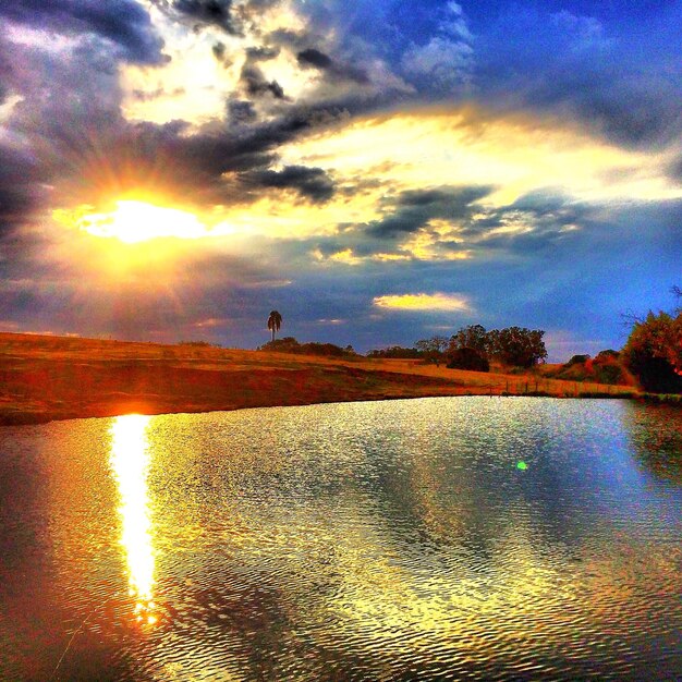 Photo scenic view of lake against cloudy sky during sunset