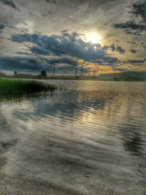 夕暮れ の 時 の 雲 の ある 空 に 対し て の 湖 の 景色