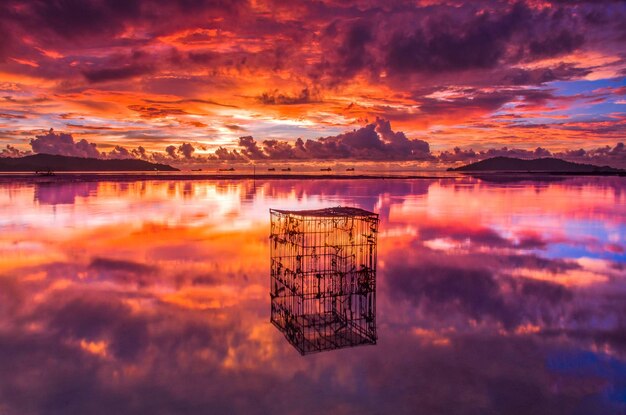 Photo scenic view of lake against dramatic sky during sunset