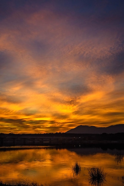 夕暮れ の 時 に 劇 的 な 空 に 対し て 湖 の 景色
