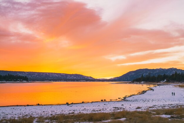 Photo scenic view of lake against orange sky during sunset